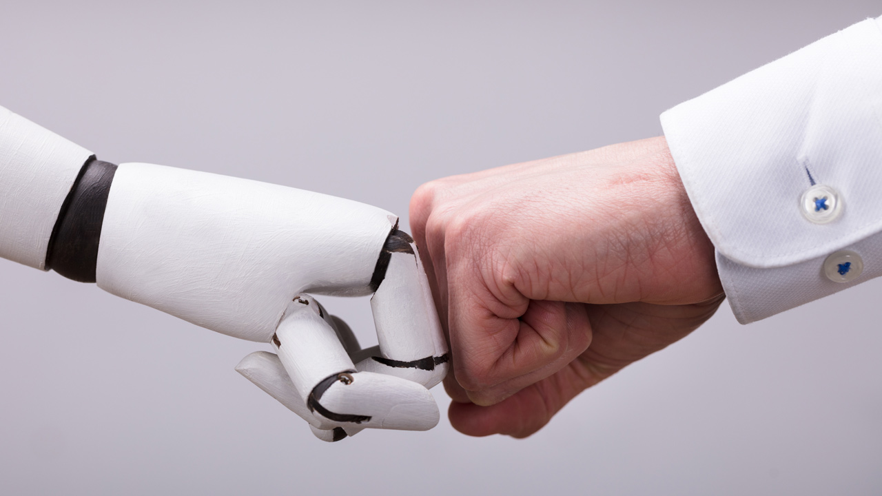 Robotin ja ihmisen nyrkit koskettavat toisiaan.